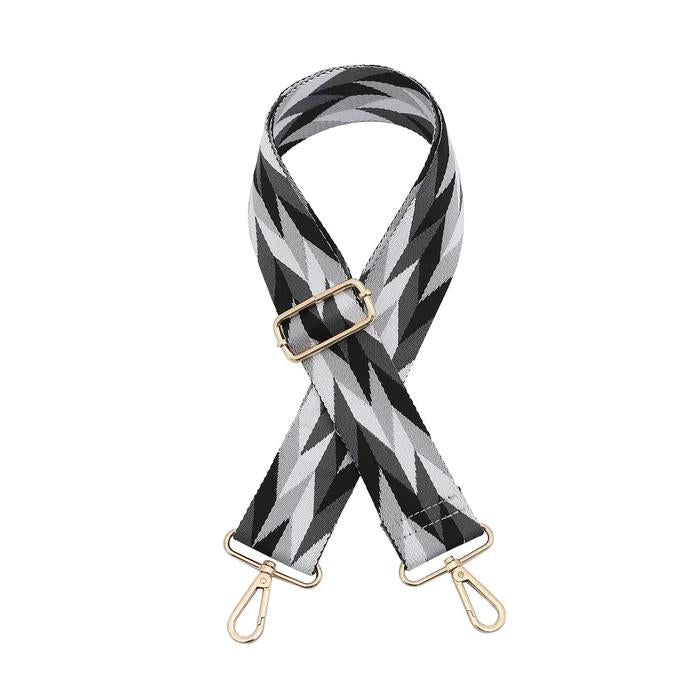 Black and white geometric bag strap with gold clasps.