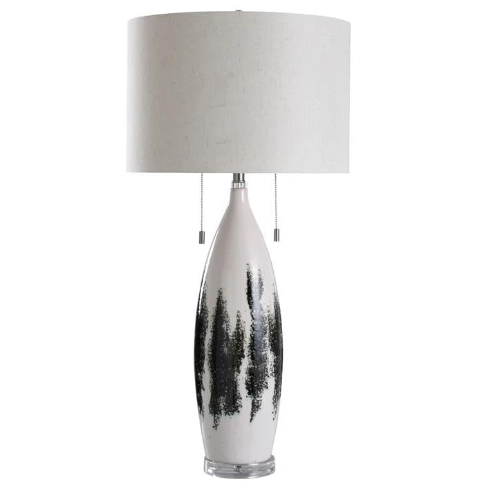 Tall lamp with abstract black design and drum shade.