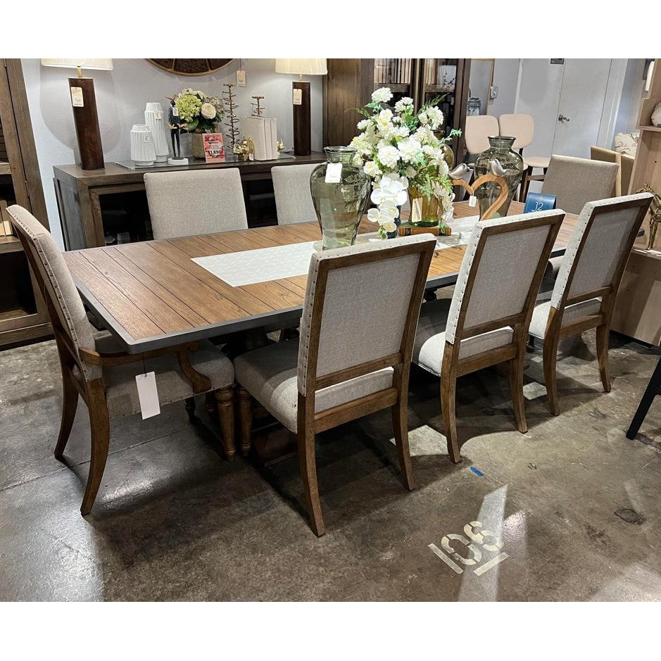 Dining set with wooden table, six chairs, and floral centerpiece.