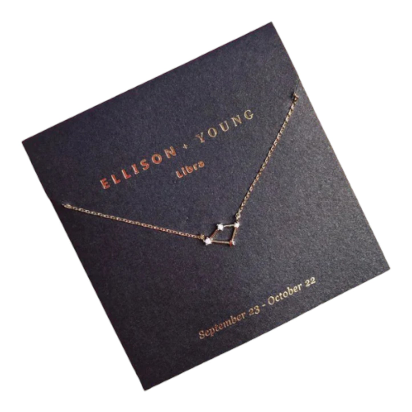 Gold Libra constellation necklace on black card.