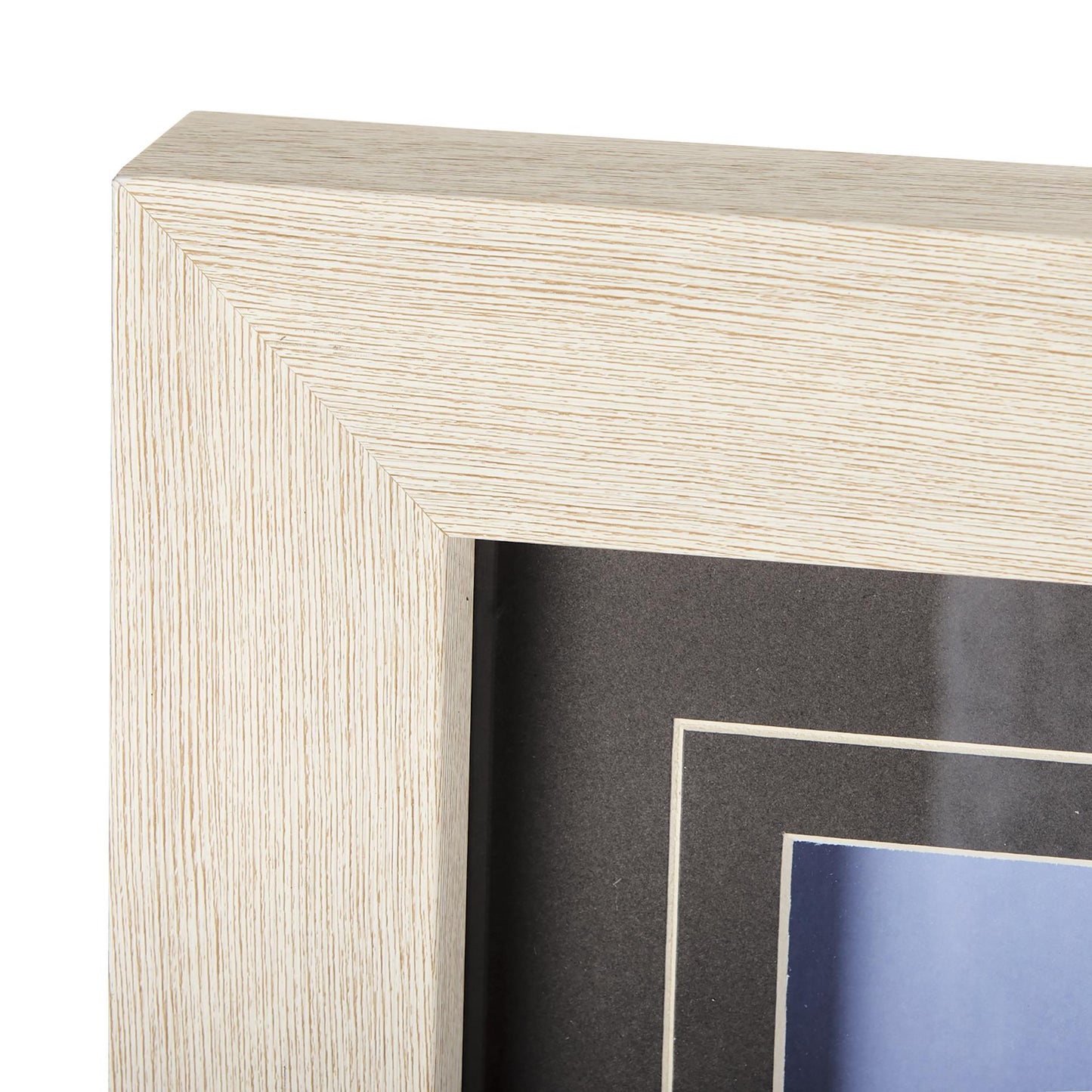 Wood-textured corner of a beige picture frame with a black mat.