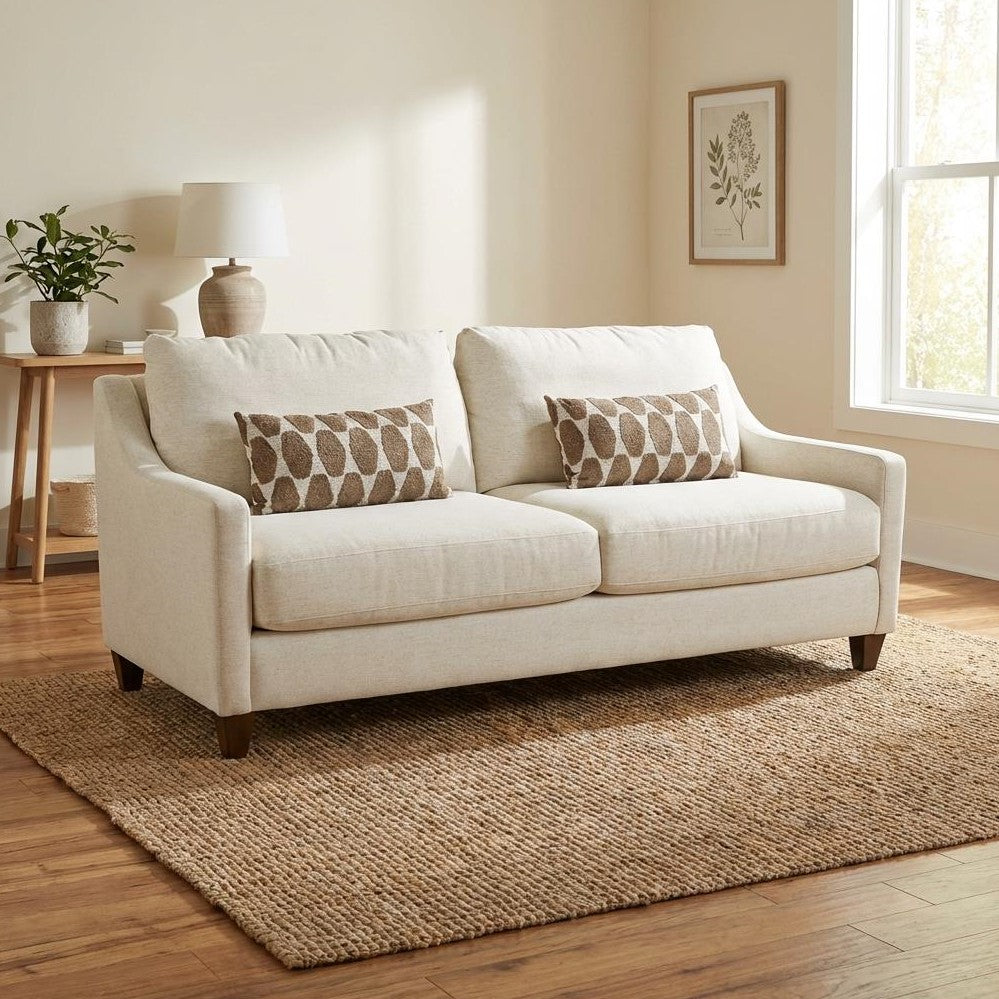 Beige sofa with patterned pillows in a cozy, sunlit living room.