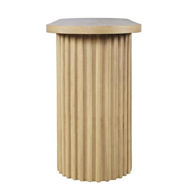 Wooden pedestal with vertical grooves and a flat top.