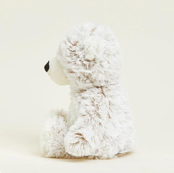 Fluffy teddy bear sitting, side view.