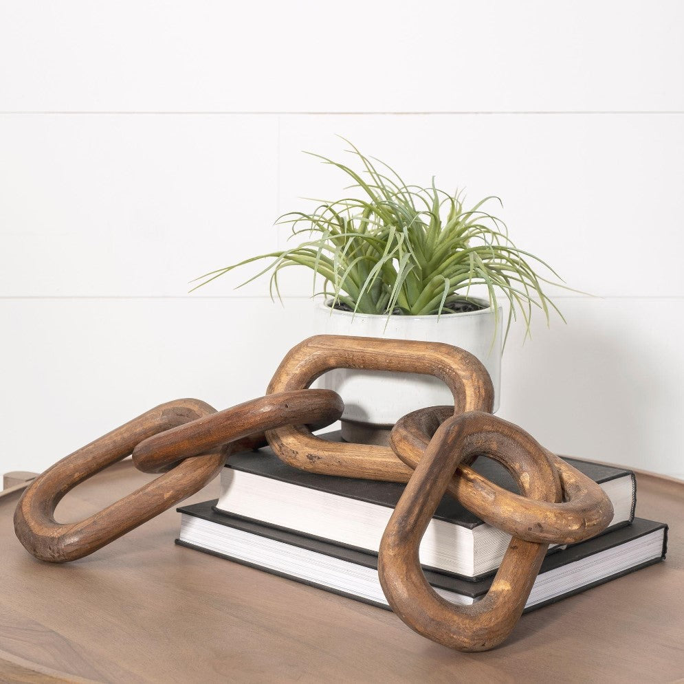 Wooden links, books, and a potted plant on a table.