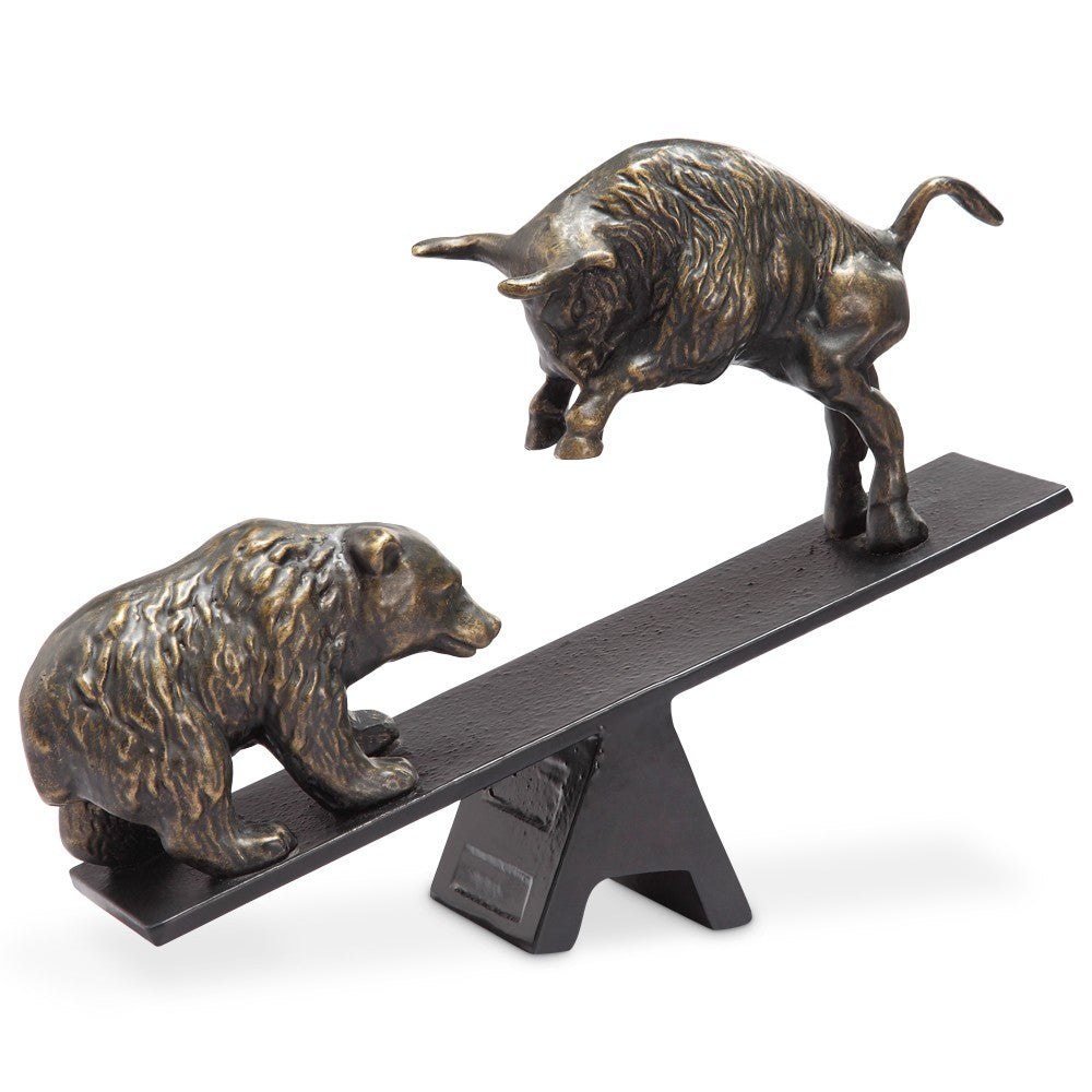 Bear and bull bronze sculptures on a seesaw.