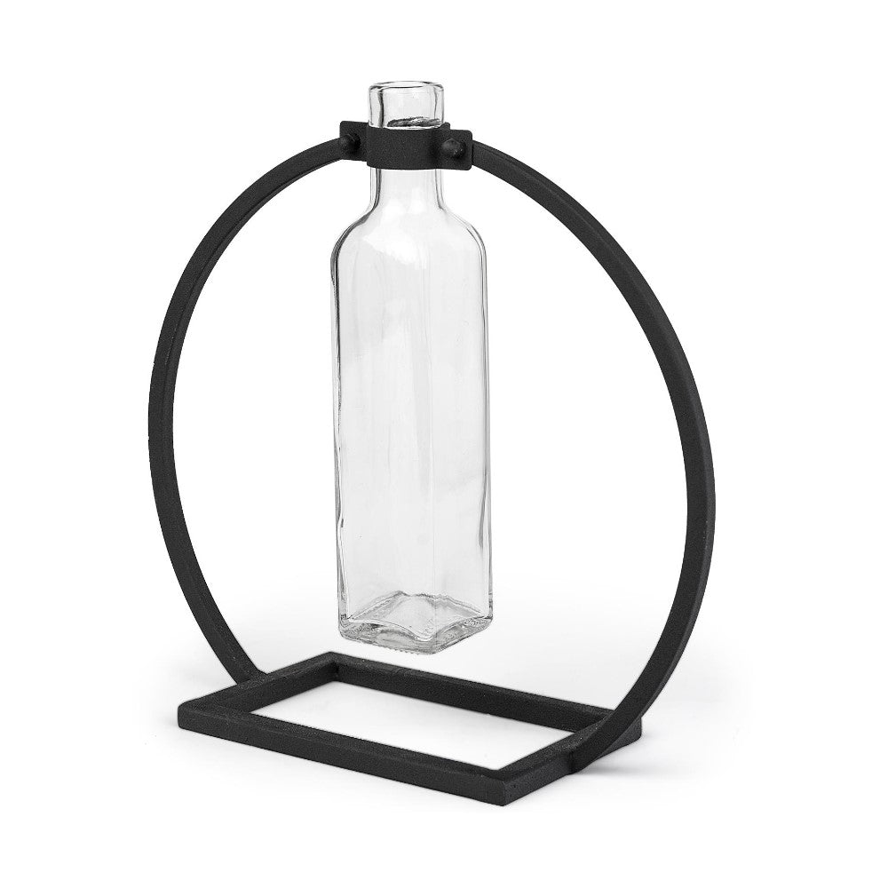 Glass bottle suspended in a black metal circular stand.