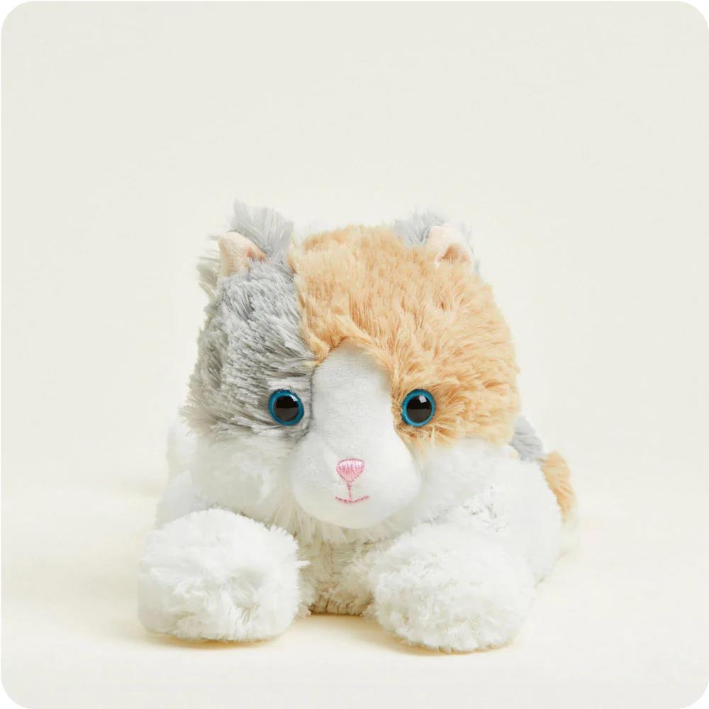 Fluffy stuffed cat toy with a calico pattern and blue eyes.