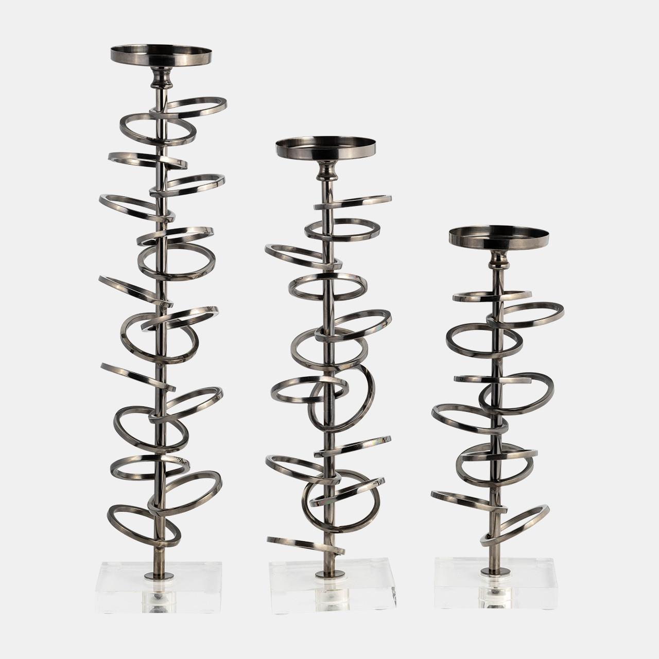 Three spiral metal candle holders on clear bases.