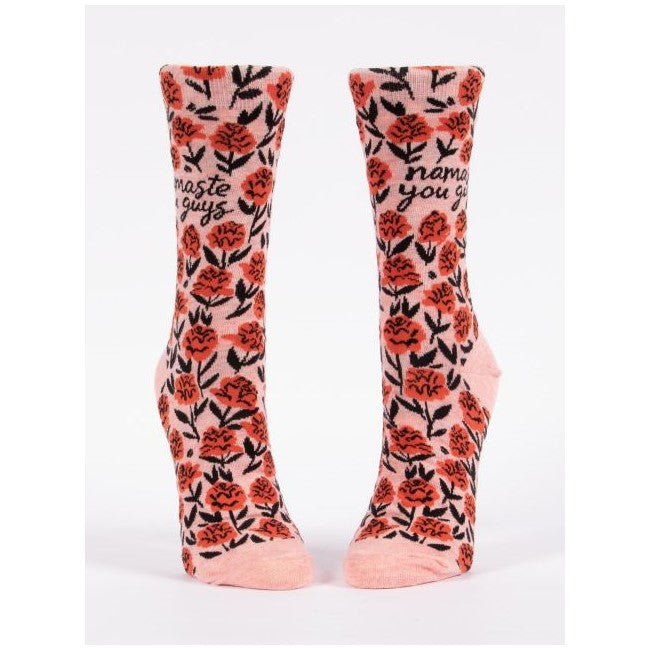 Pink socks with red flowers and "namaste you guys" text.
