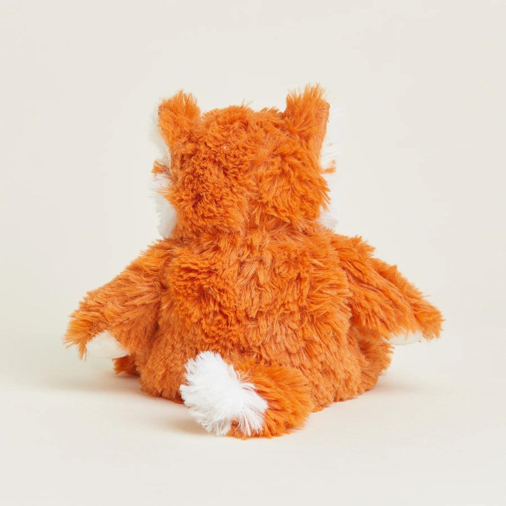 Orange plush fox toy sitting, facing away.