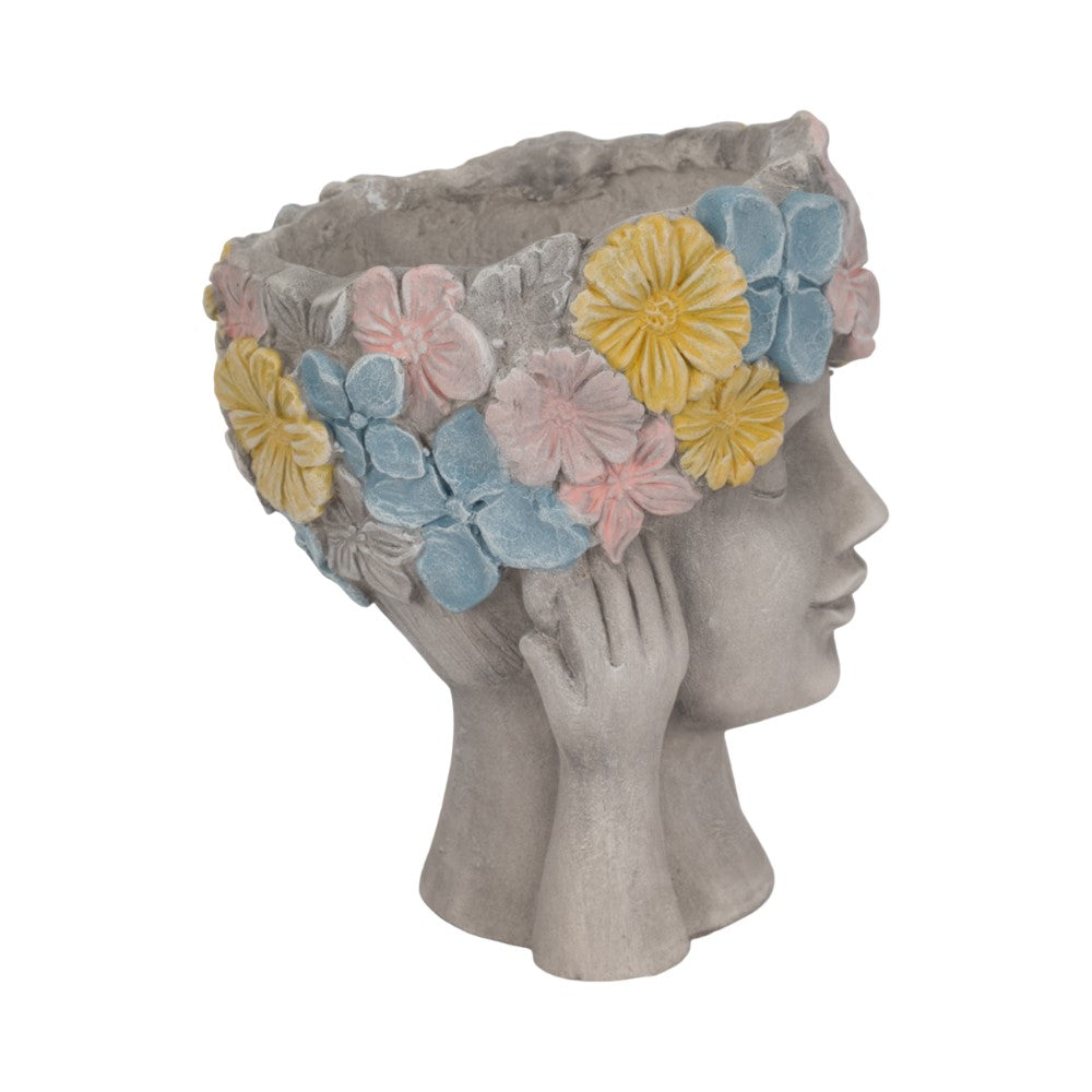Stone planter shaped like a head with colorful flower crown.