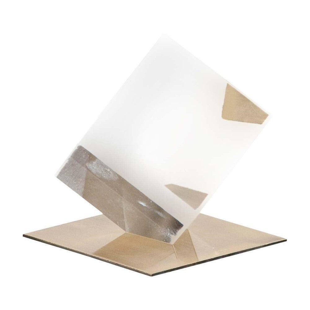 Transparent prism balancing on a flat surface.