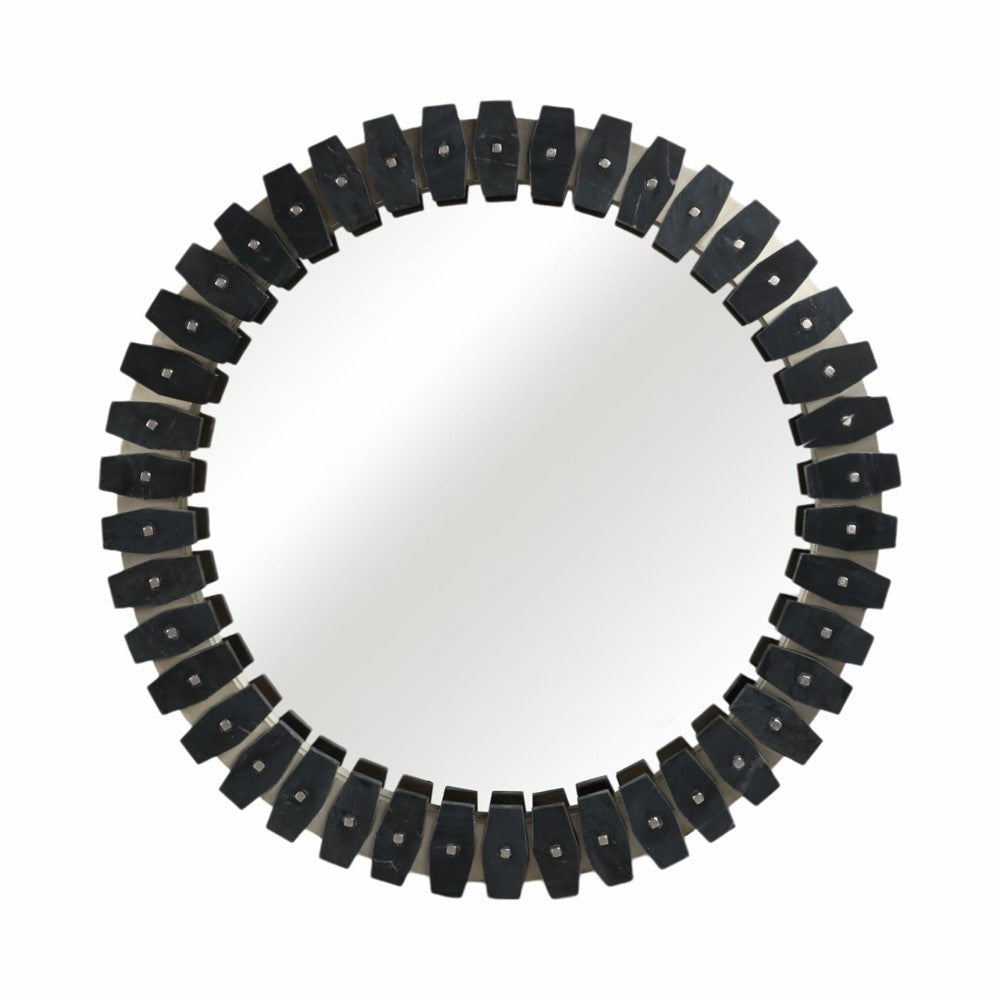Circular mirror with a dark geometric patterned frame.
