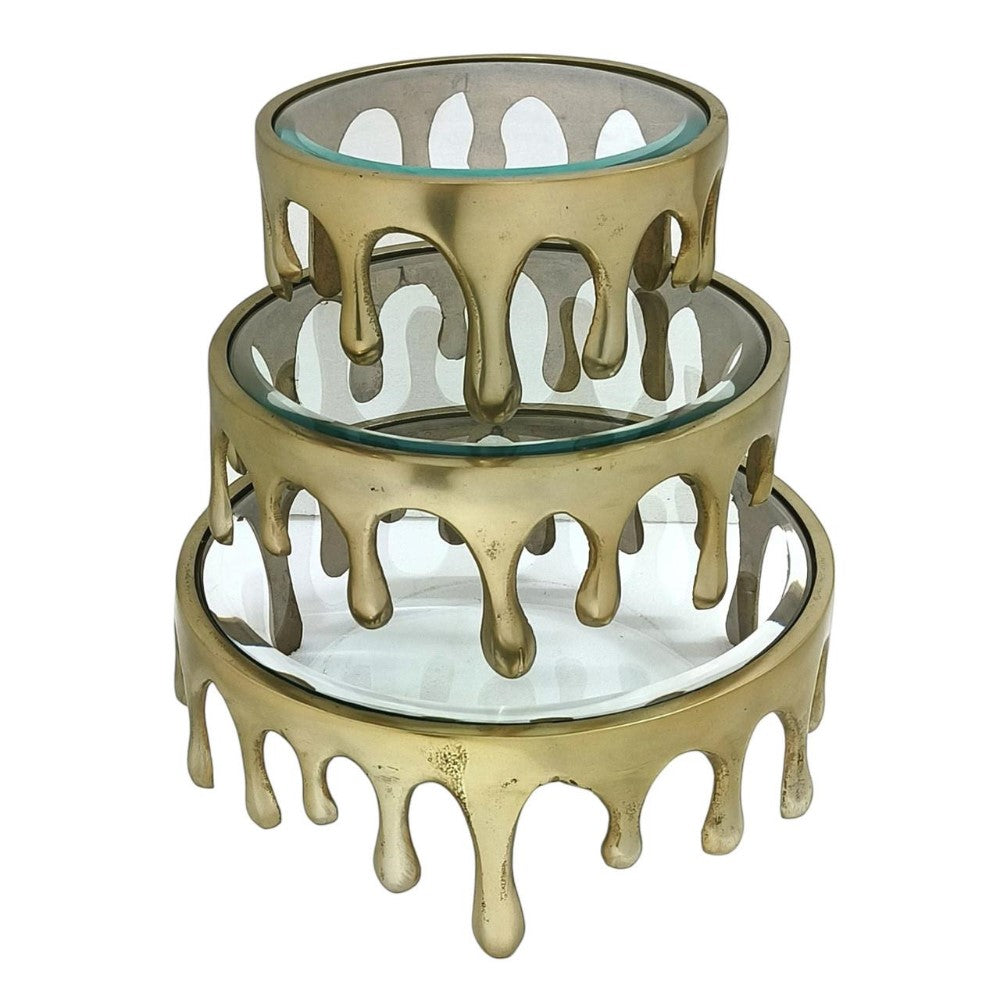 Three-tiered gold trays with drip design and glass surfaces.