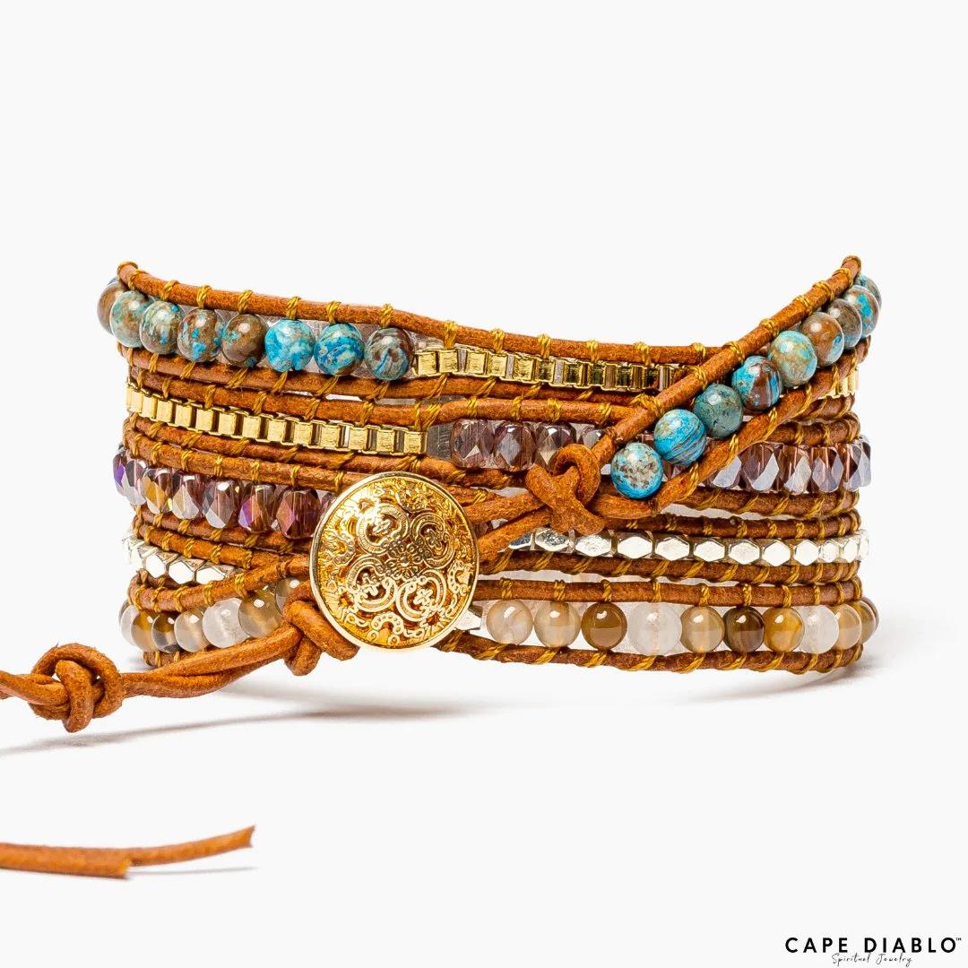 Wrap bracelet with blue stones, gold beads, and ornate button closure.