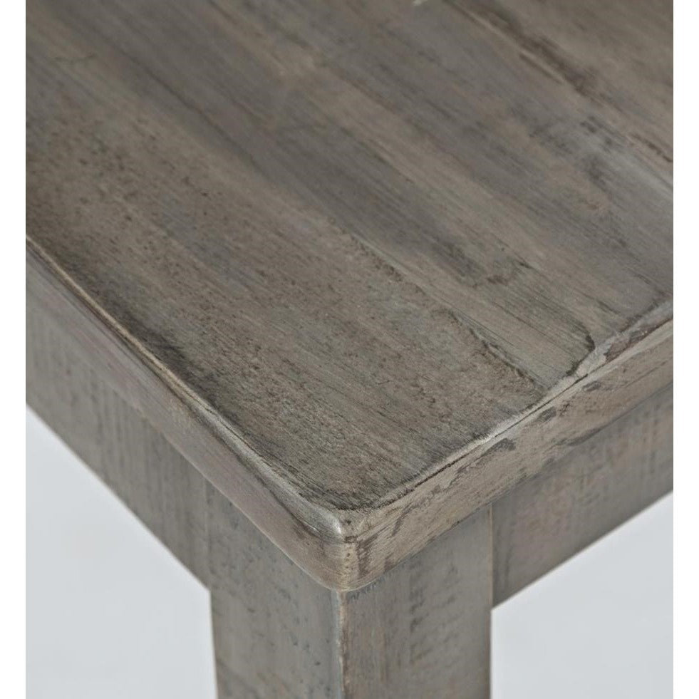 Close-up of a weathered wooden table corner with a smooth finish.