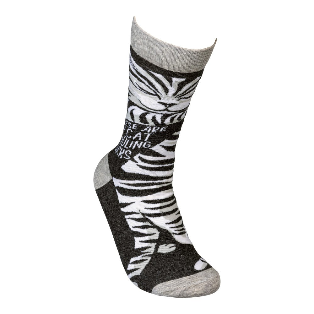 Black and white zebra-patterned sock with playful text.