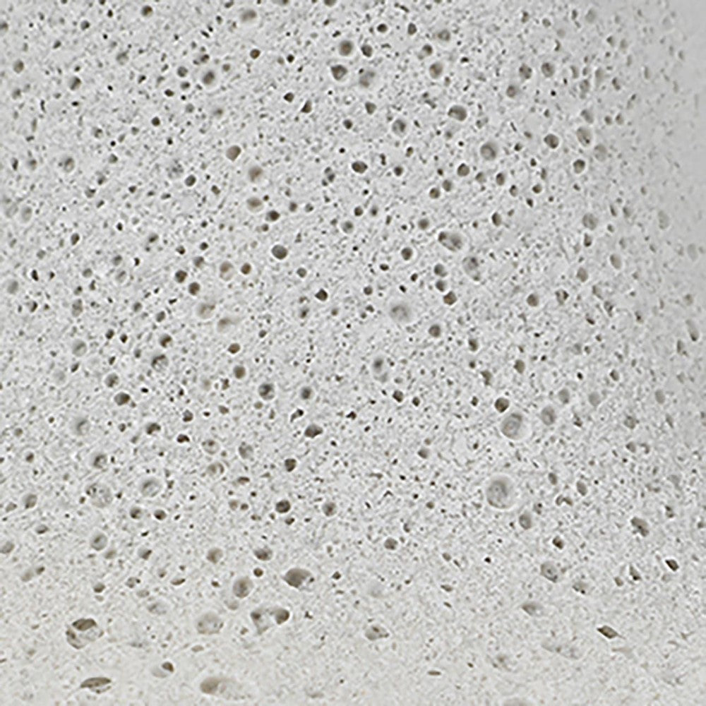 Close-up of a porous, gray surface with small holes.