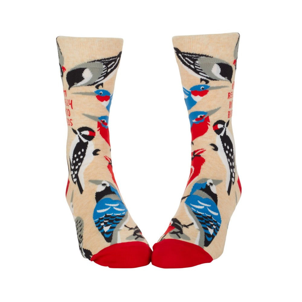 Colorful bird-patterned socks with red toes and beige background.