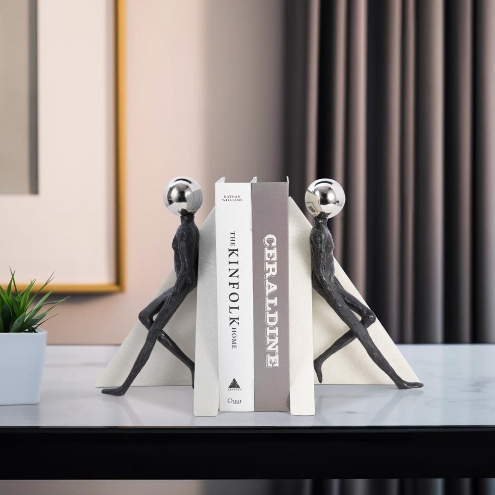 Statue bookends holding two books on a modern table.