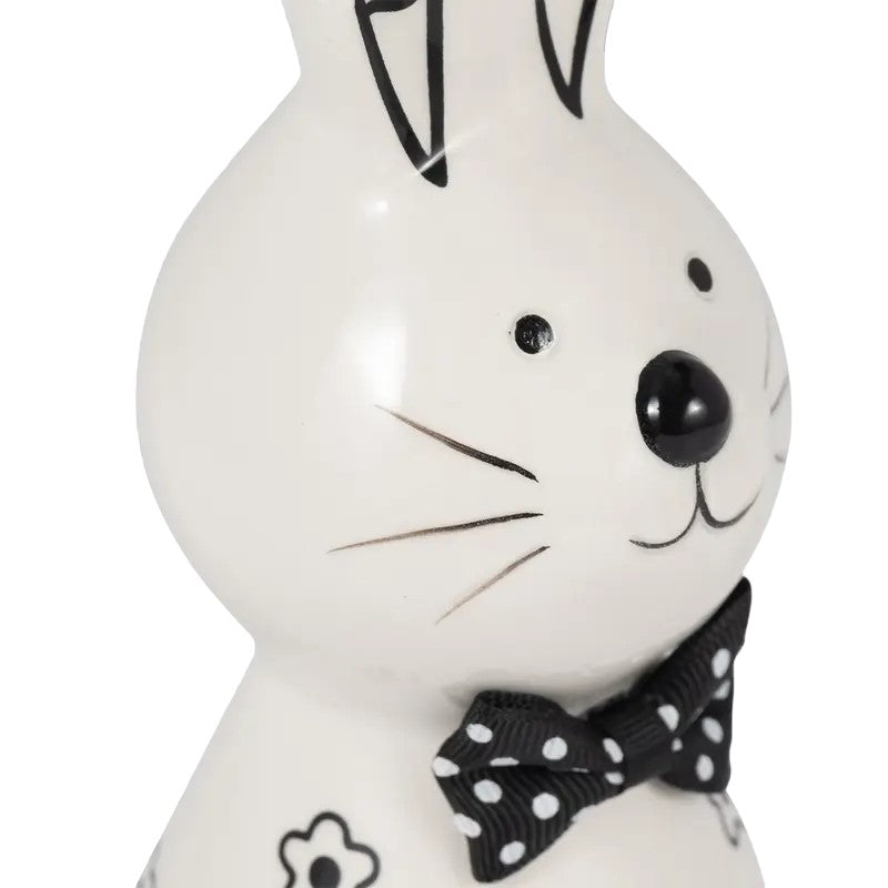 White ceramic bunny with a black bow tie and floral accents.