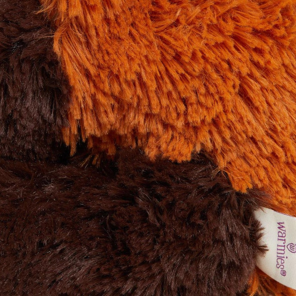 Close-up of plush toy fur in orange and brown tones.