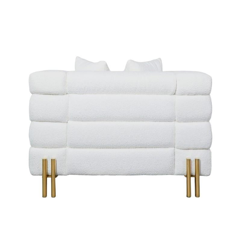 White plush sofa with gold legs, viewed from the back.