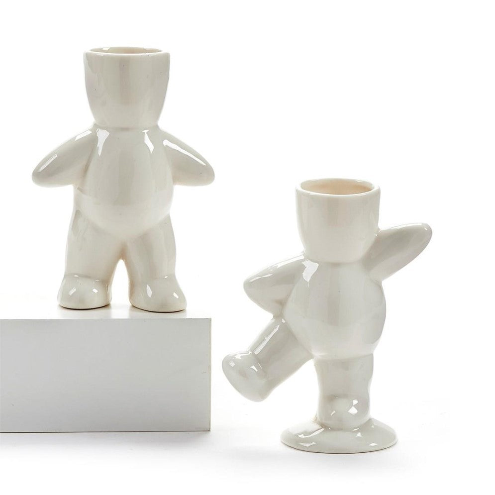 Two white ceramic figurine vases on display.