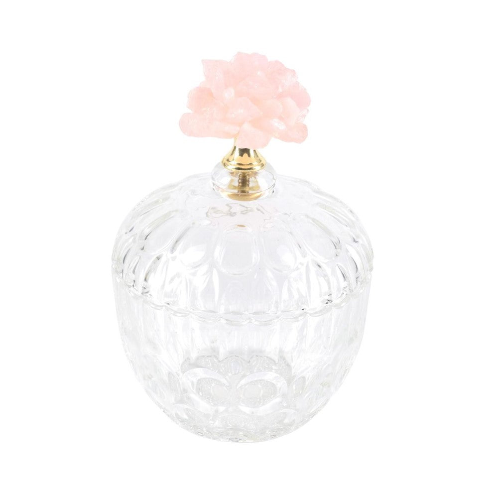 Ornate glass jar with pink decorative lid, gold accent.