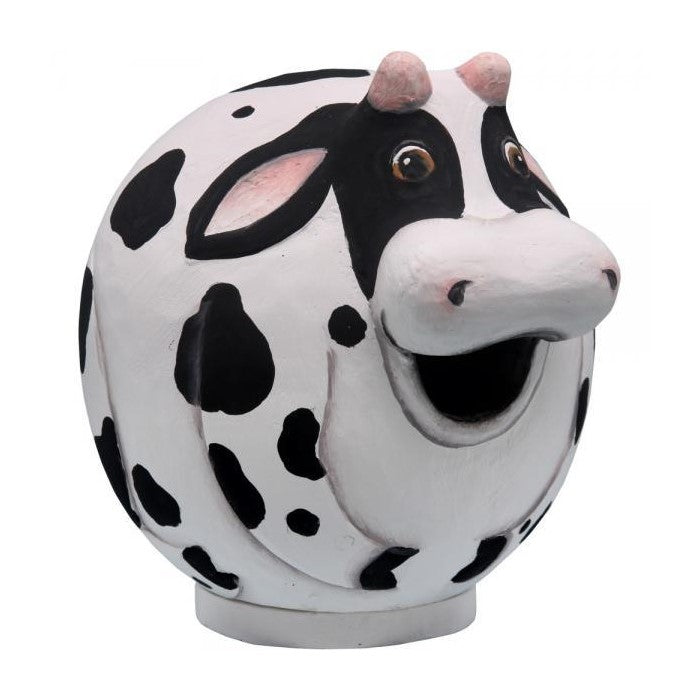 Round cow sculpture with a smiling face and black spots.
