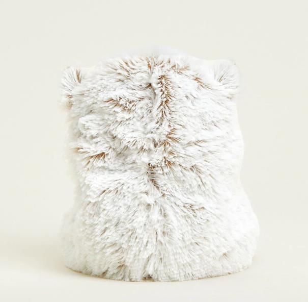 Fluffy white object with soft fur texture on a light background.
