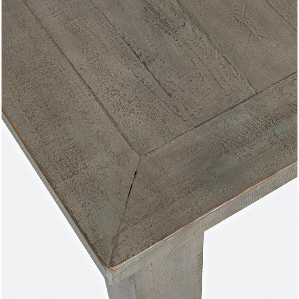 Close-up of a wooden table corner with a rustic finish.