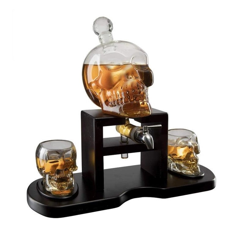 Skull-shaped glass decanter set with two shot glasses.