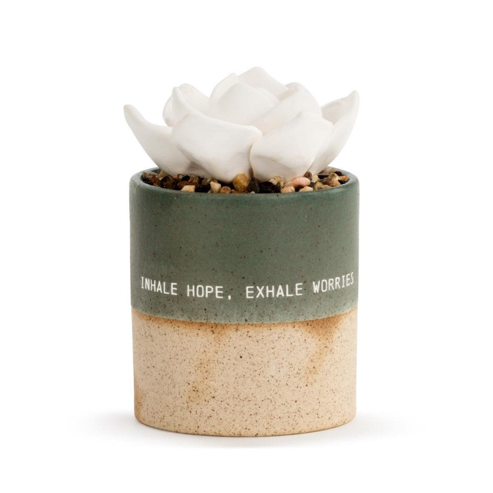 Ceramic pot with white flower, motivational text: "Inhale hope, exhale worries."