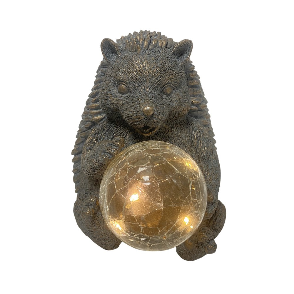 Hedgehog statue holding a glowing crackled glass ball.