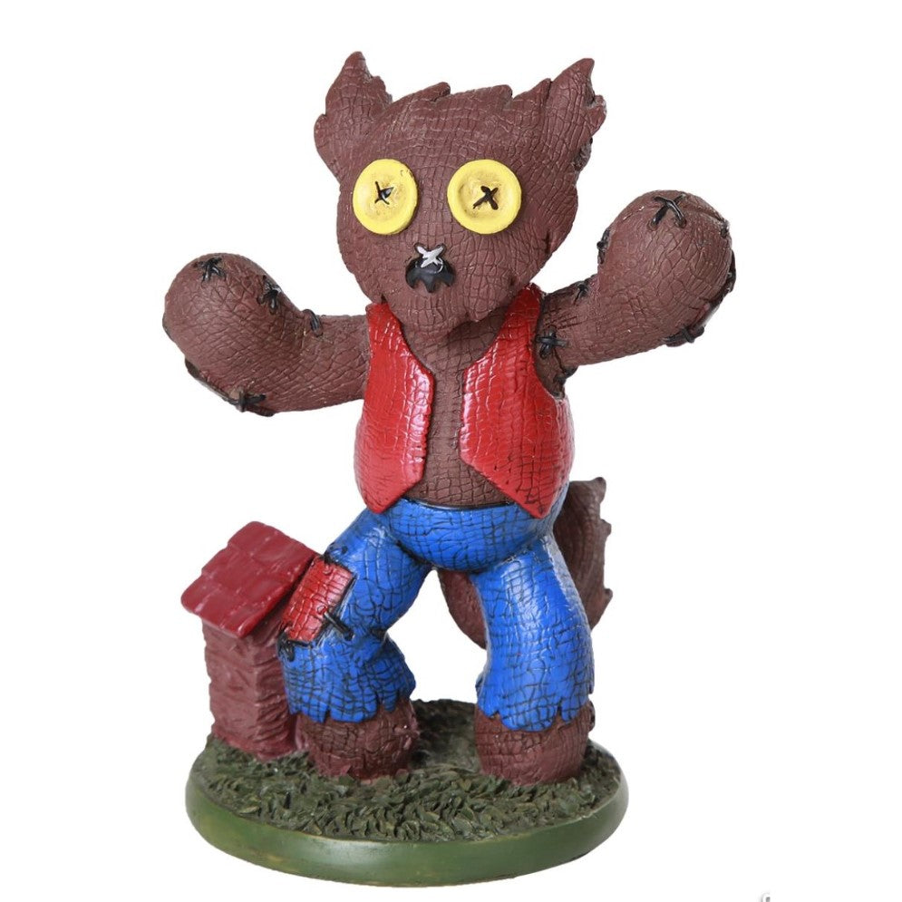Patchy scarecrow figure with button eyes and red vest.