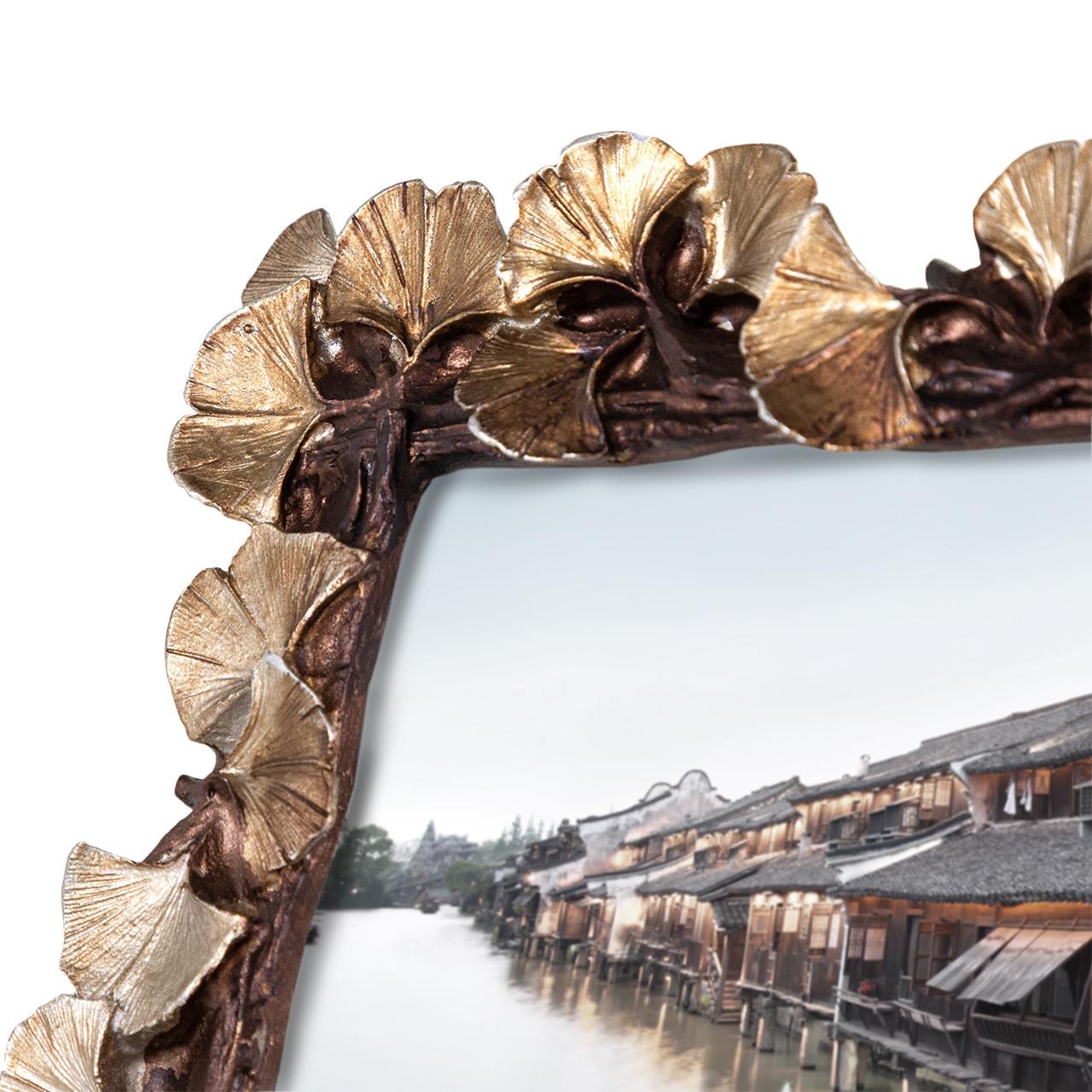 Decorative frame with ginkgo leaf design, showcasing a riverside town image.