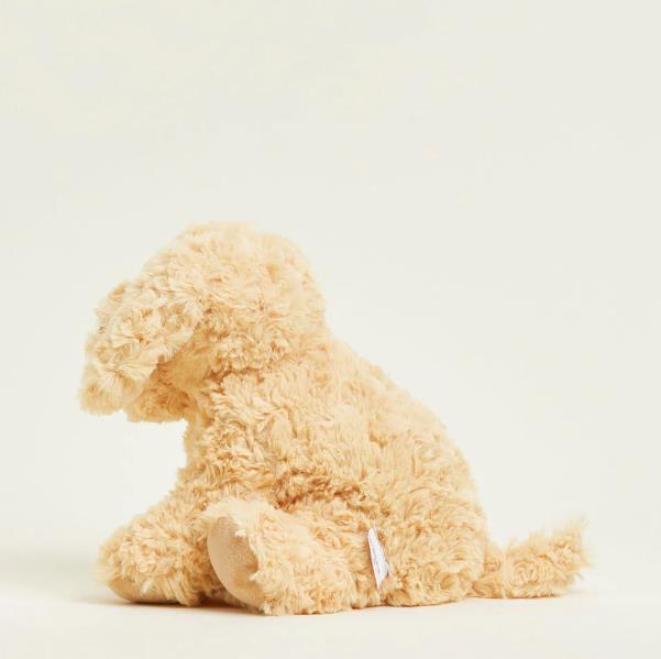 Fluffy beige plush dog sitting against a plain background.