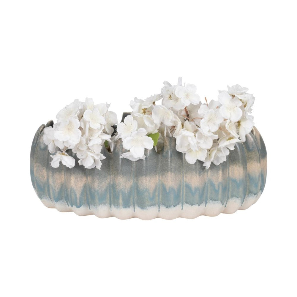 Ceramic vase with white flowers in a wavy, textured design.