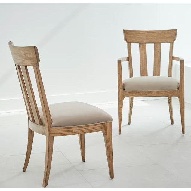 Two wooden chairs with beige cushions in a bright, white room.