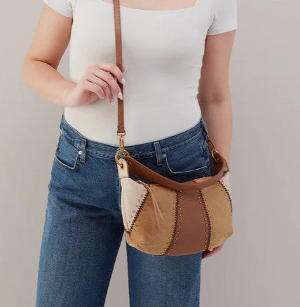 Person holding a stylish brown and beige shoulder bag.