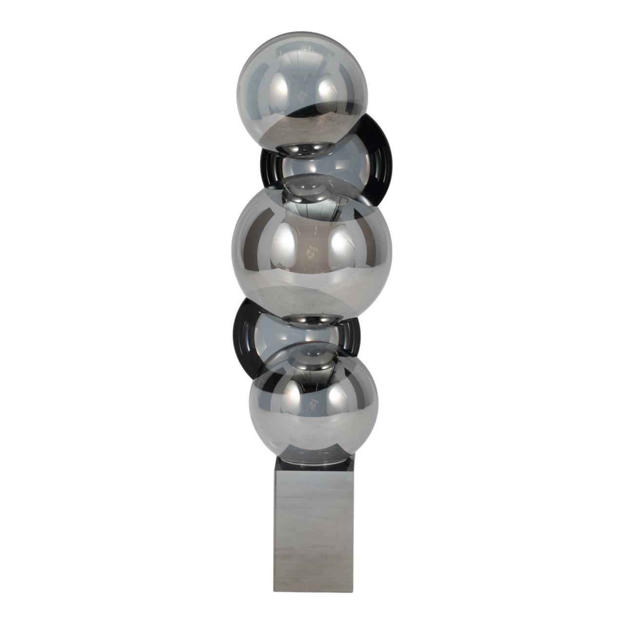 Four stacked reflective spheres on a rectangular base.