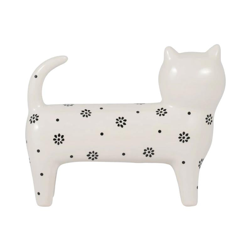 White cat figurine with black flower patterns and a raised tail.