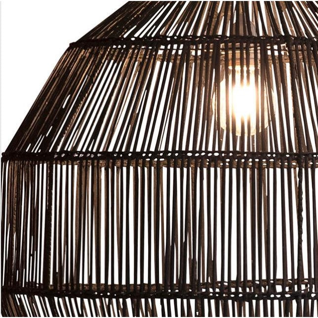 Woven wicker lamp with bright bulb inside.