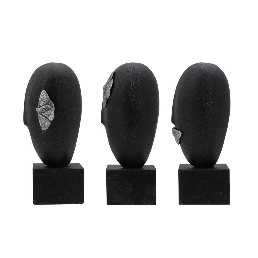 Three black abstract head sculptures with silver leaf details.