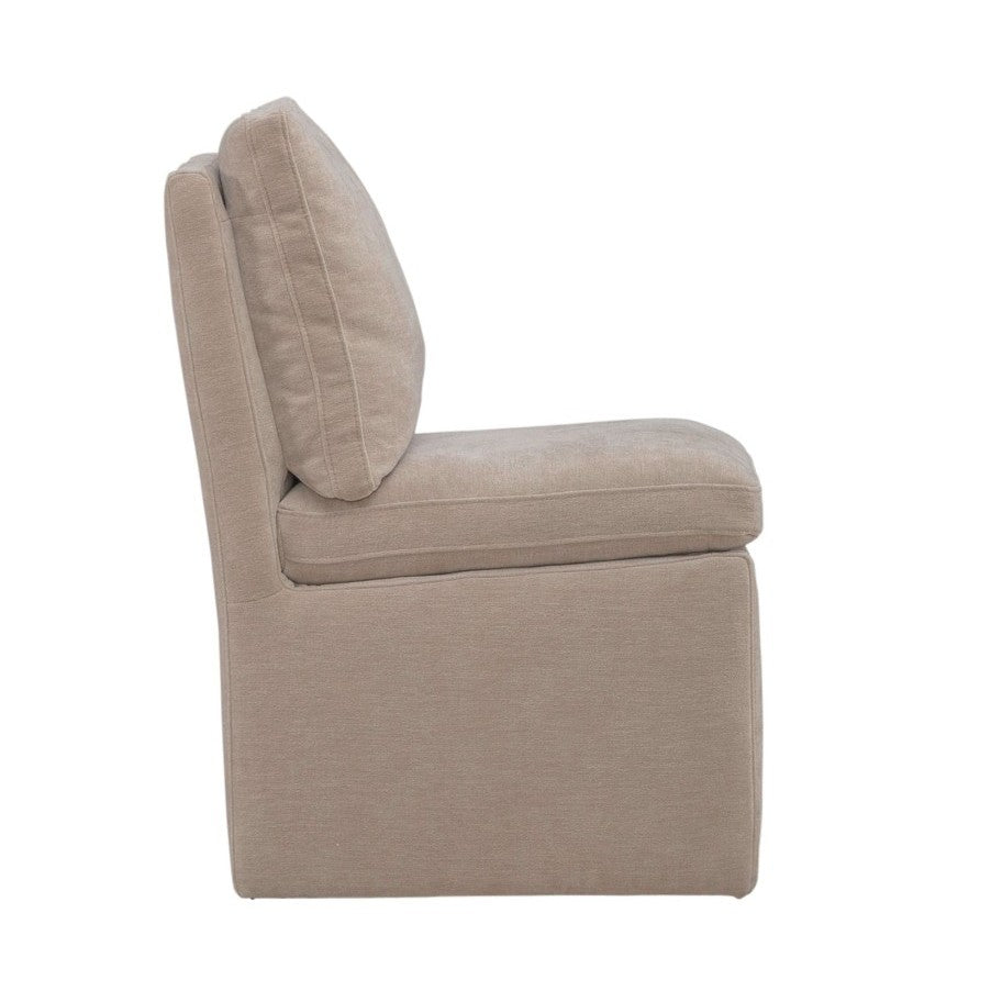 Beige armless chair with thick cushions, viewed from the side.