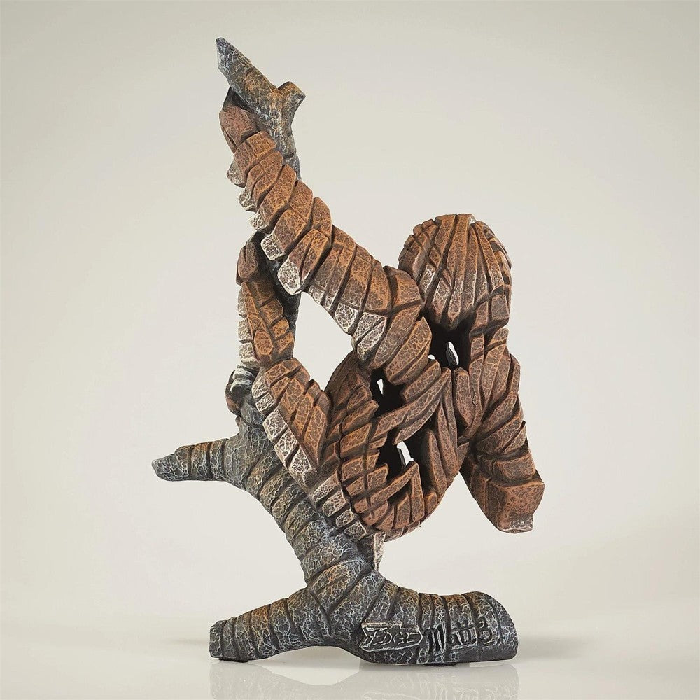 Abstract stone sculpture of a figure climbing.