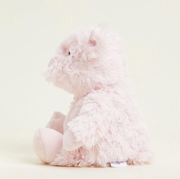 Fluffy pink teddy bear sitting in profile.