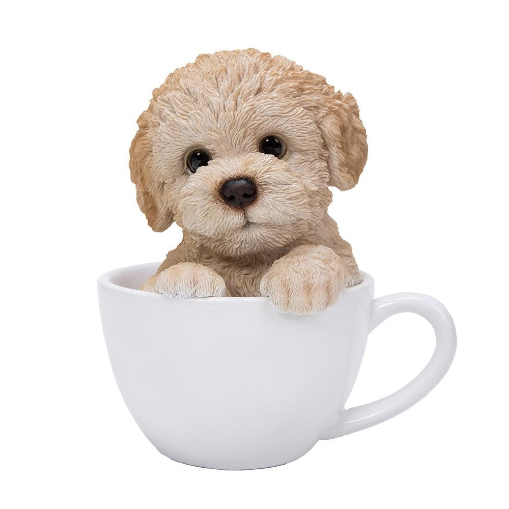 Cute puppy figurine peeking out of a white cup.
